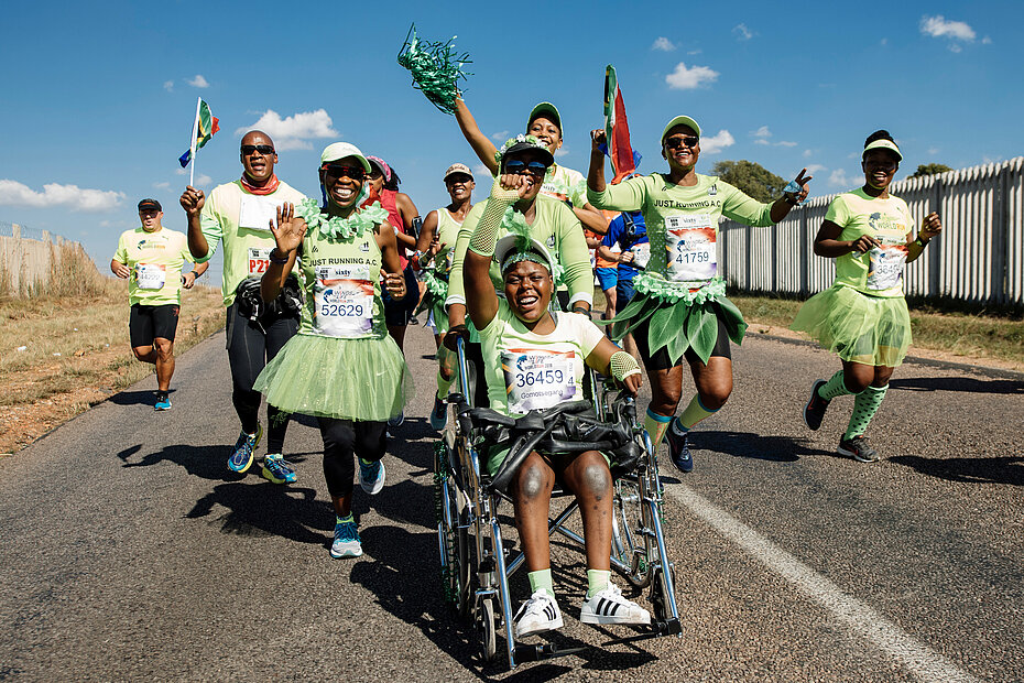 Wings for Life World Run participants running as a team in green costumes in South Africa
