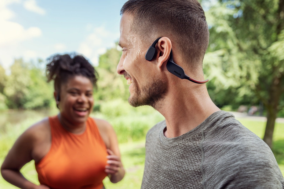 Active man and woman outside with Philips sports headphones